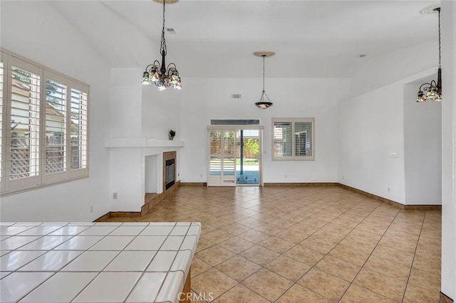 658 Tusky Ave, Los Banos, CA 93635 - unfurnished living room with a chandelier, plenty of natural light, light tile patterned floors, and lofted ceiling