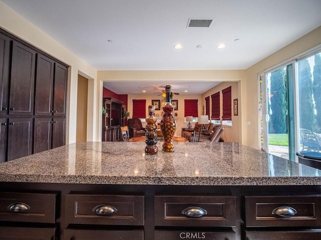 9275 Serenity St, Riverside, CA 92508 - kitchen featuring dark brown cabinetry, a center island, recessed lighting, a ceiling fan, and dark stone countertops