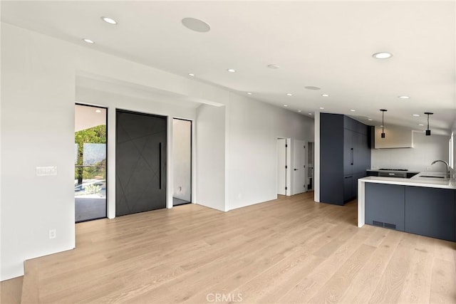9336 Lloydcrest Dr, Beverly Hills, CA 90210 - kitchen with modern cabinets, light wood-type flooring, recessed lighting, light countertops, and hanging light fixtures