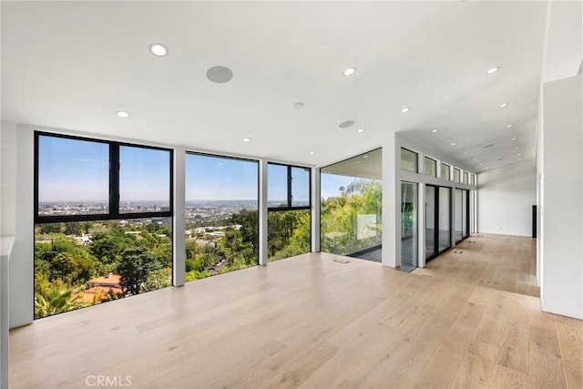 9336 Lloydcrest Dr, Beverly Hills, CA 90210 - empty room featuring wood finished floors, plenty of natural light, floor to ceiling windows, and recessed lighting