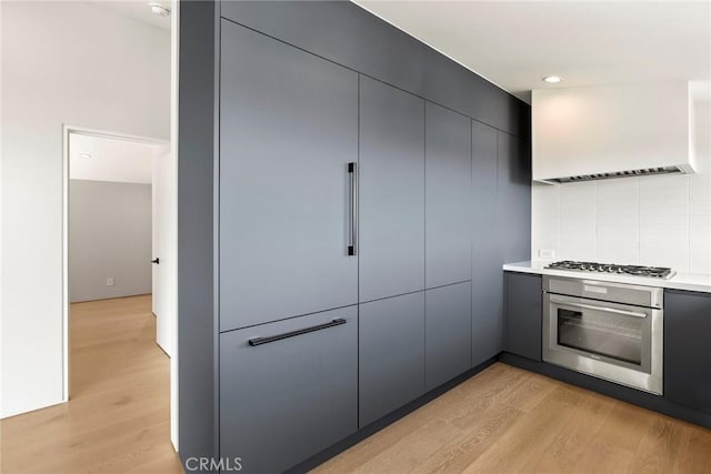 9336 Lloydcrest Dr, Beverly Hills, CA 90210 - kitchen featuring stainless steel appliances, light wood-type flooring, modern cabinets, custom exhaust hood, and light countertops