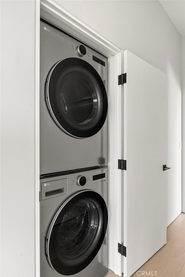 9336 Lloydcrest Dr, Beverly Hills, CA 90210 - laundry room with stacked washer / drying machine and light wood-style floors