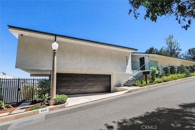 9336 Lloydcrest Dr, Beverly Hills, CA 90210 - contemporary house with stucco siding, stairs, a garage, and driveway
