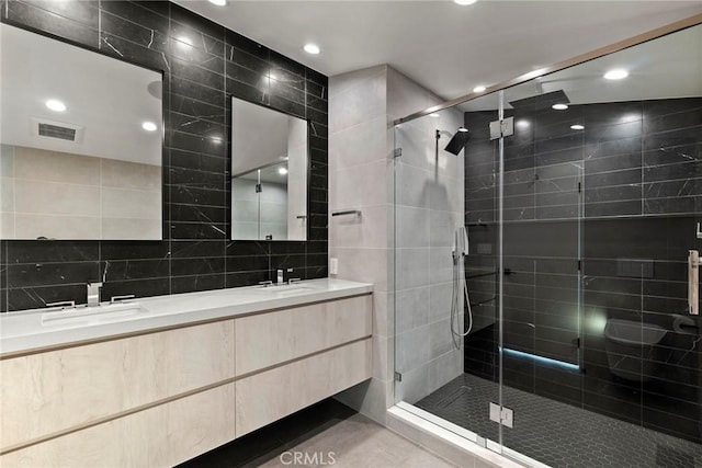 9336 Lloydcrest Dr, Beverly Hills, CA 90210 - bathroom featuring tile walls, double vanity, a stall shower, recessed lighting, and tile patterned flooring