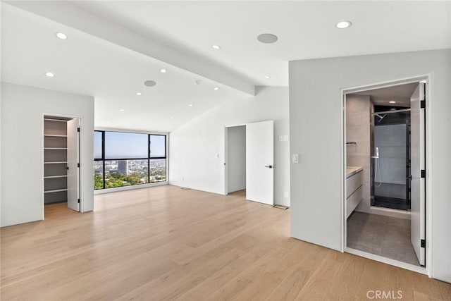 9336 Lloydcrest Dr, Beverly Hills, CA 90210 - unfurnished bedroom with light wood-style floors, a walk in closet, recessed lighting, ensuite bath, and expansive windows