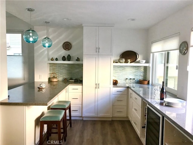 2577 Plaza Del Amo Unit 712, Torrance, CA 90503 - kitchen with open shelves, a peninsula, beverage cooler, dark wood finished floors, and white cabinetry