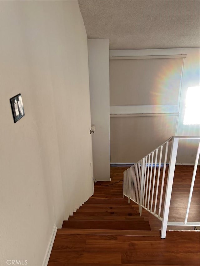 5257 Radford Ave Unit 308, Valley Village, CA 91607 - stairs featuring wood finished floors and a textured ceiling