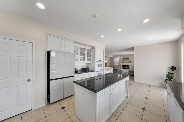 45339 Tiburcio Dr, Temecula, CA 92592 - kitchen with white appliances, a kitchen island, white cabinets, glass insert cabinets, and recessed lighting