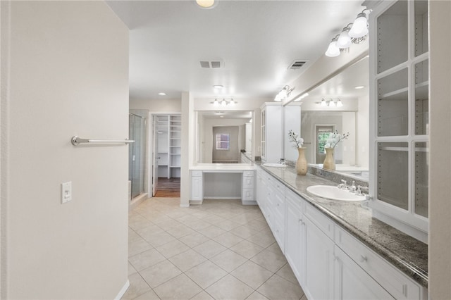45339 Tiburcio Dr, Temecula, CA 92592 - full bath with double vanity, tile patterned floors, a shower stall, and a walk in closet
