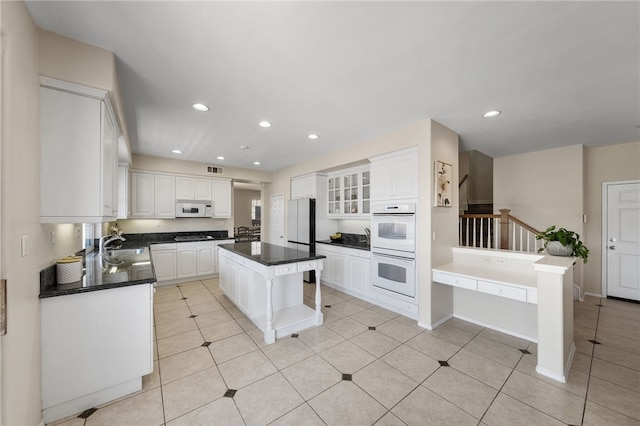 45339 Tiburcio Dr, Temecula, CA 92592 - kitchen featuring white appliances, dark countertops, white cabinetry, and recessed lighting