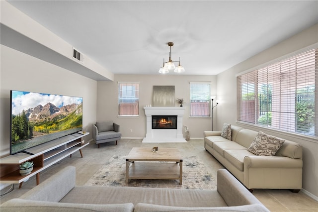 45339 Tiburcio Dr, Temecula, CA 92592 - living room with a glass covered fireplace, tile patterned floors, and a chandelier