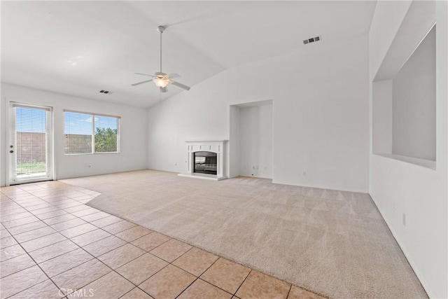 42619 Meridian Way, Lancaster, CA 93536 - unfurnished living room with light colored carpet, lofted ceiling, a ceiling fan, light tile patterned floors, and a glass covered fireplace
