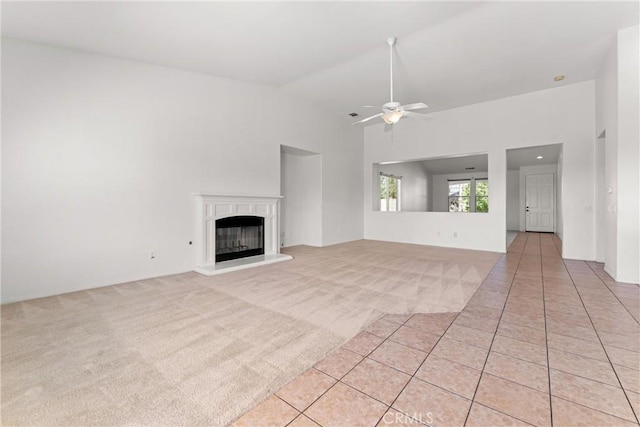 42619 Meridian Way, Lancaster, CA 93536 - unfurnished living room featuring a ceiling fan, light colored carpet, a glass covered fireplace, and high vaulted ceiling