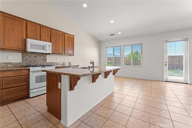 42619 Meridian Way, Lancaster, CA 93536 - kitchen with white appliances, light tile patterned floors, vaulted ceiling, healthy amount of natural light, and brown cabinetry