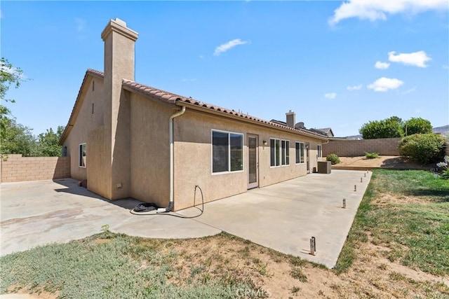 42619 Meridian Way, Lancaster, CA 93536 - rear view of property with a chimney, a fenced backyard, stucco siding, and a patio