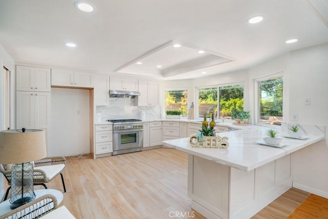 20329 Rim Ridge Rd, Walnut, CA 91789 - kitchen with a peninsula, light countertops, a raised ceiling, white cabinets, and light wood finished floors