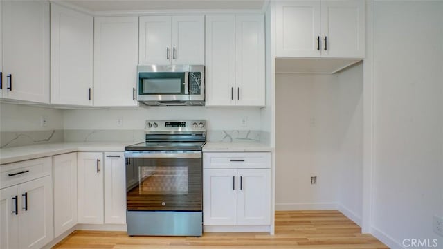856 W 47th St, Los Angeles, CA 90037 - kitchen featuring stainless steel appliances, light wood-style floors, and white cabinets