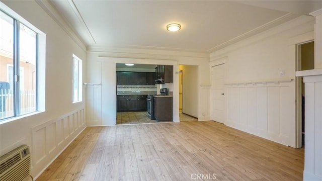 856 W 47th St, Los Angeles, CA 90037 - unfurnished living room featuring a decorative wall, light wood-style floors, ornamental molding, wainscoting, and a wall mounted AC