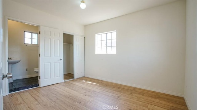 856 W 47th St, Los Angeles, CA 90037 - unfurnished bedroom featuring light wood finished floors, a closet, and ensuite bath