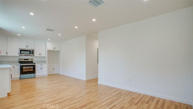 856 W 47th St, Los Angeles, CA 90037 - kitchen featuring appliances with stainless steel finishes, light wood-style floors, light countertops, recessed lighting, and open floor plan