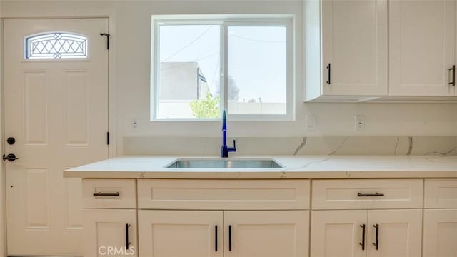 856 W 47th St, Los Angeles, CA 90037 - kitchen with healthy amount of natural light, white cabinetry, and light stone countertops
