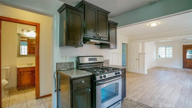 856 W 47th St, Los Angeles, CA 90037 - kitchen with gas stove, under cabinet range hood, light wood-style flooring, dark stone countertops, and ornamental molding