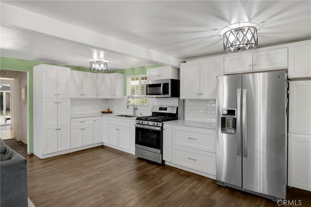 1003 Stevenson St, Colton, CA 92324 - kitchen with stainless steel appliances, decorative backsplash, light countertops, white cabinets, and dark wood-style flooring