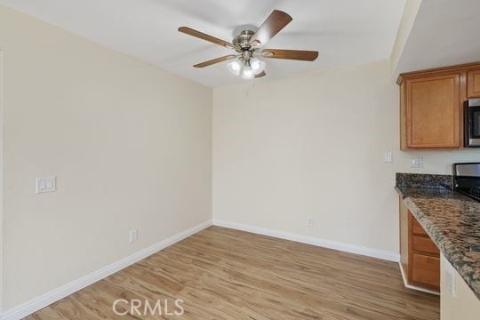 1313 Massachusettes Ave Unit 203, Riverside, CA 92507 - unfurnished dining area with light wood finished floors, a ceiling fan, and built in desk