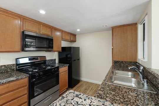 1313 Massachusettes Ave Unit 203, Riverside, CA 92507 - kitchen with stainless steel appliances, light wood-style flooring, brown cabinets, and recessed lighting