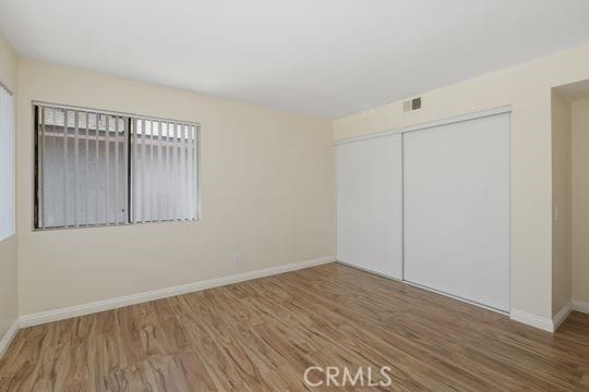 1313 Massachusettes Ave Unit 203, Riverside, CA 92507 - unfurnished bedroom with wood finished floors and a closet