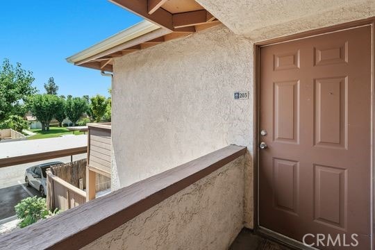 1313 Massachusettes Ave Unit 203, Riverside, CA 92507 - doorway to property featuring stucco siding and a balcony