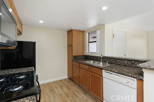 1313 Massachusettes Ave Unit 203, Riverside, CA 92507 - kitchen featuring dishwasher, gas stove, brown cabinetry, light wood finished floors, and dark stone countertops
