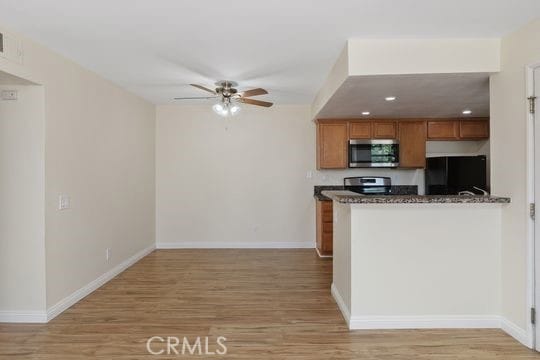 1313 Massachusettes Ave Unit 203, Riverside, CA 92507 - kitchen featuring stainless steel microwave, fridge, brown cabinets, ceiling fan, and light wood finished floors