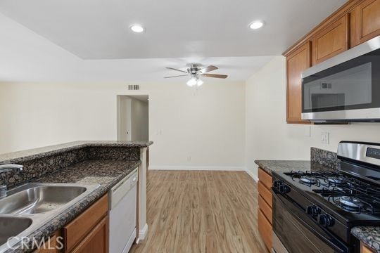 1313 Massachusettes Ave Unit 203, Riverside, CA 92507 - kitchen featuring gas range, stainless steel microwave, white dishwasher, ceiling fan, and brown cabinets