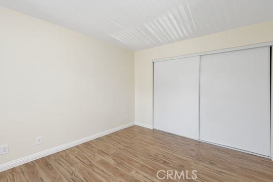 1313 Massachusettes Ave Unit 203, Riverside, CA 92507 - unfurnished bedroom featuring wood finished floors and a closet
