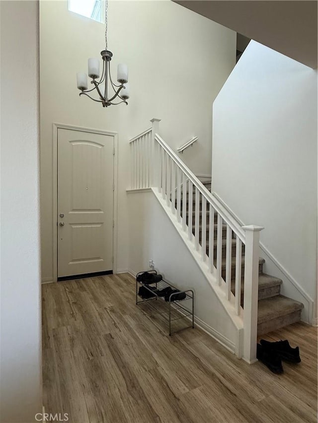 12708 Ojo Caliente St, Victorville, CA 92392 - entrance foyer featuring wood finished floors, stairway, a chandelier, and a high ceiling
