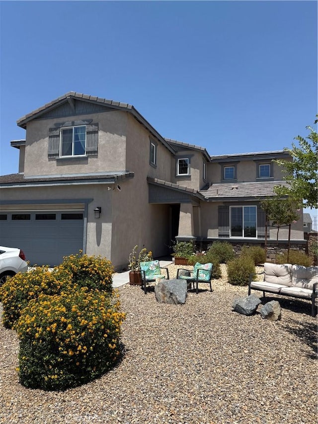12708 Ojo Caliente St, Victorville, CA 92392 - view of front of property with an attached garage, stucco siding, and an outdoor living space