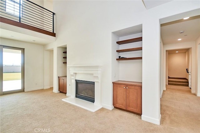 245 Snapdragon Ln, Glendora, CA 91741 - unfurnished living room featuring light colored carpet, a glass covered fireplace, and built in shelves