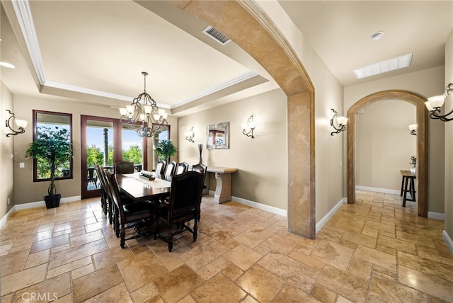 43650 La Cruz Dr, Temecula, CA 92590 - dining space with stone tile floors, arched walkways, a raised ceiling, a chandelier, and crown molding