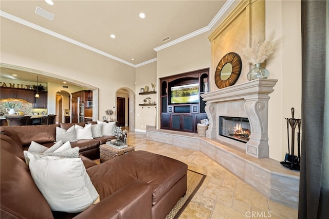 43650 La Cruz Dr, Temecula, CA 92590 - living room featuring arched walkways, crown molding, built in features, recessed lighting, and stone tile flooring