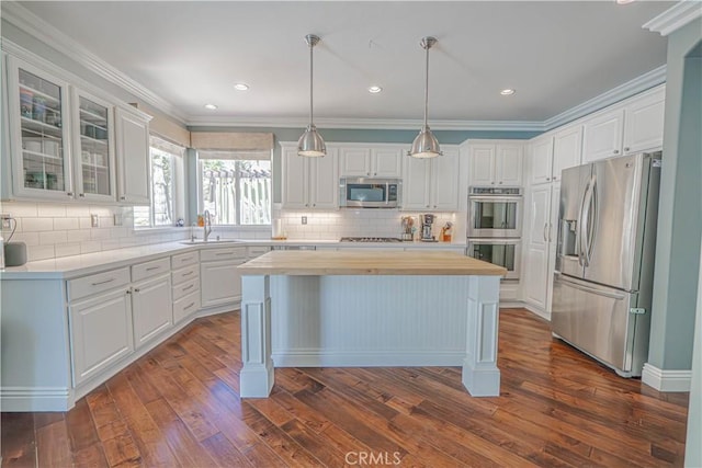 25531 Durant Pl, Stevenson Ranch, CA 91381 - kitchen with appliances with stainless steel finishes, a kitchen island, white cabinets, dark wood-style floors, and recessed lighting