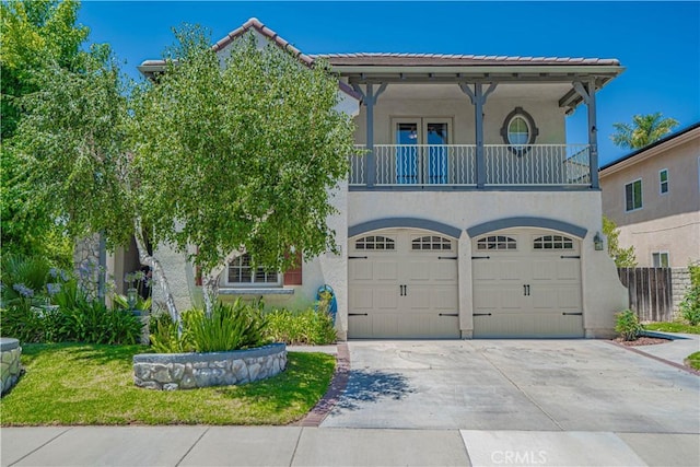 25531 Durant Pl, Stevenson Ranch, CA 91381 - mediterranean / spanish house with a balcony, driveway, stucco siding, an attached garage, and a tiled roof