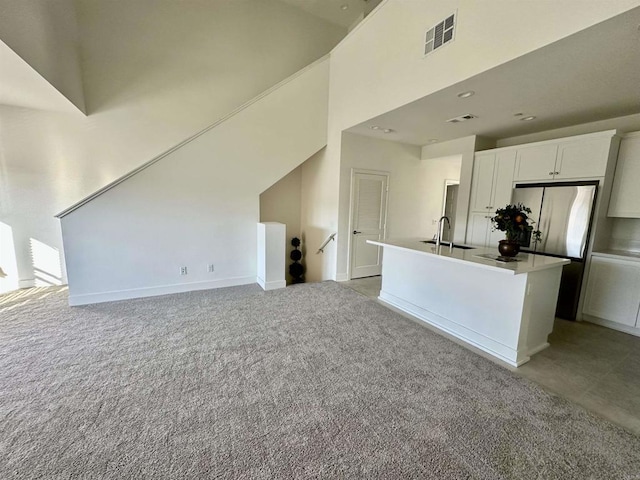 2170 Birch Rd Unit 111, Chula Vista, CA 91915 - kitchen featuring white cabinetry, a center island with sink, freestanding refrigerator, and light colored carpet
