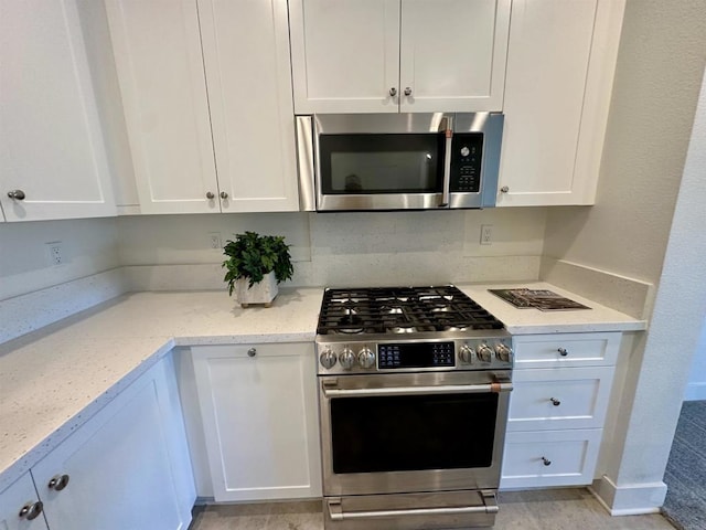 2170 Birch Rd Unit 111, Chula Vista, CA 91915 - kitchen featuring appliances with stainless steel finishes, white cabinetry, and light stone countertops
