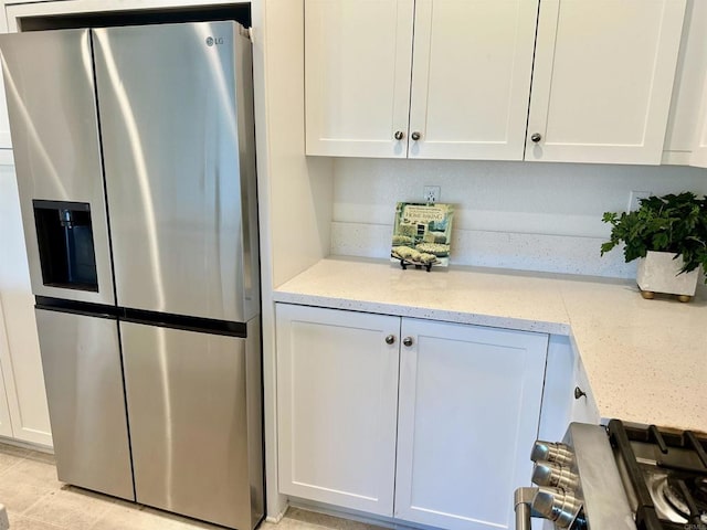 2170 Birch Rd Unit 111, Chula Vista, CA 91915 - kitchen featuring stainless steel fridge, white cabinetry, and light stone counters
