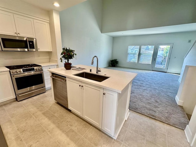 2170 Birch Rd Unit 111, Chula Vista, CA 91915 - kitchen with appliances with stainless steel finishes, light colored carpet, white cabinets, an island with sink, and recessed lighting