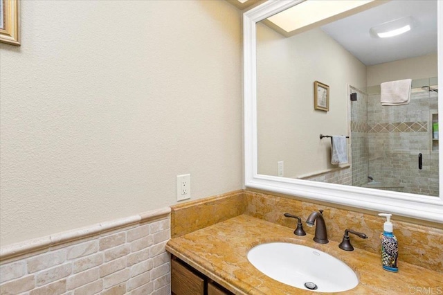 4635 Allende Ave, Oceanside, CA 92057 - bathroom featuring vanity, a stall shower, wainscoting, and tile walls