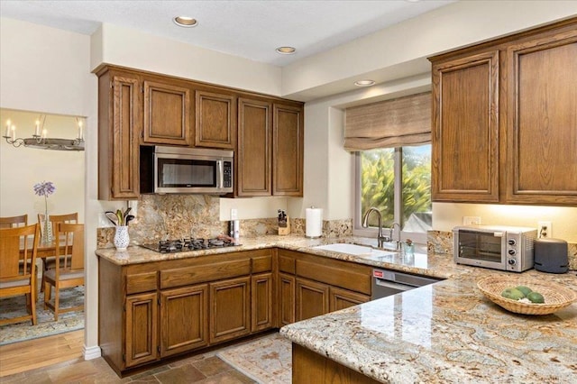 4635 Allende Ave, Oceanside, CA 92057 - kitchen featuring appliances with stainless steel finishes, light stone countertops, brown cabinets, and recessed lighting
