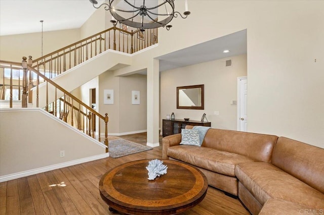 4635 Allende Ave, Oceanside, CA 92057 - living room with hardwood / wood-style flooring, a towering ceiling, a chandelier, and stairs