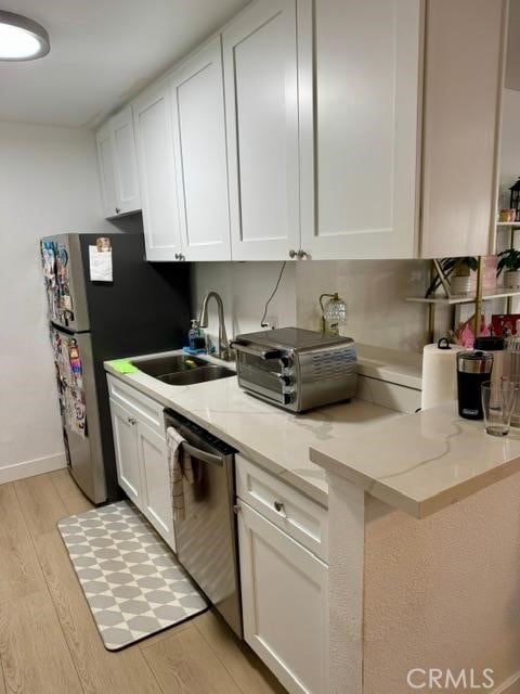 5700 Etiwanda Ave Unit 105, Tarzana, CA 91356 - kitchen with stainless steel dishwasher, light wood finished floors, and white cabinetry